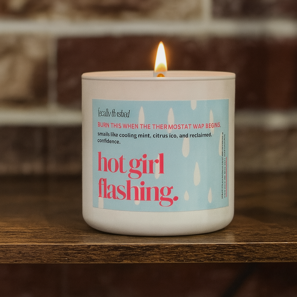 Candle with a label on a wooden surface against a brick wall background