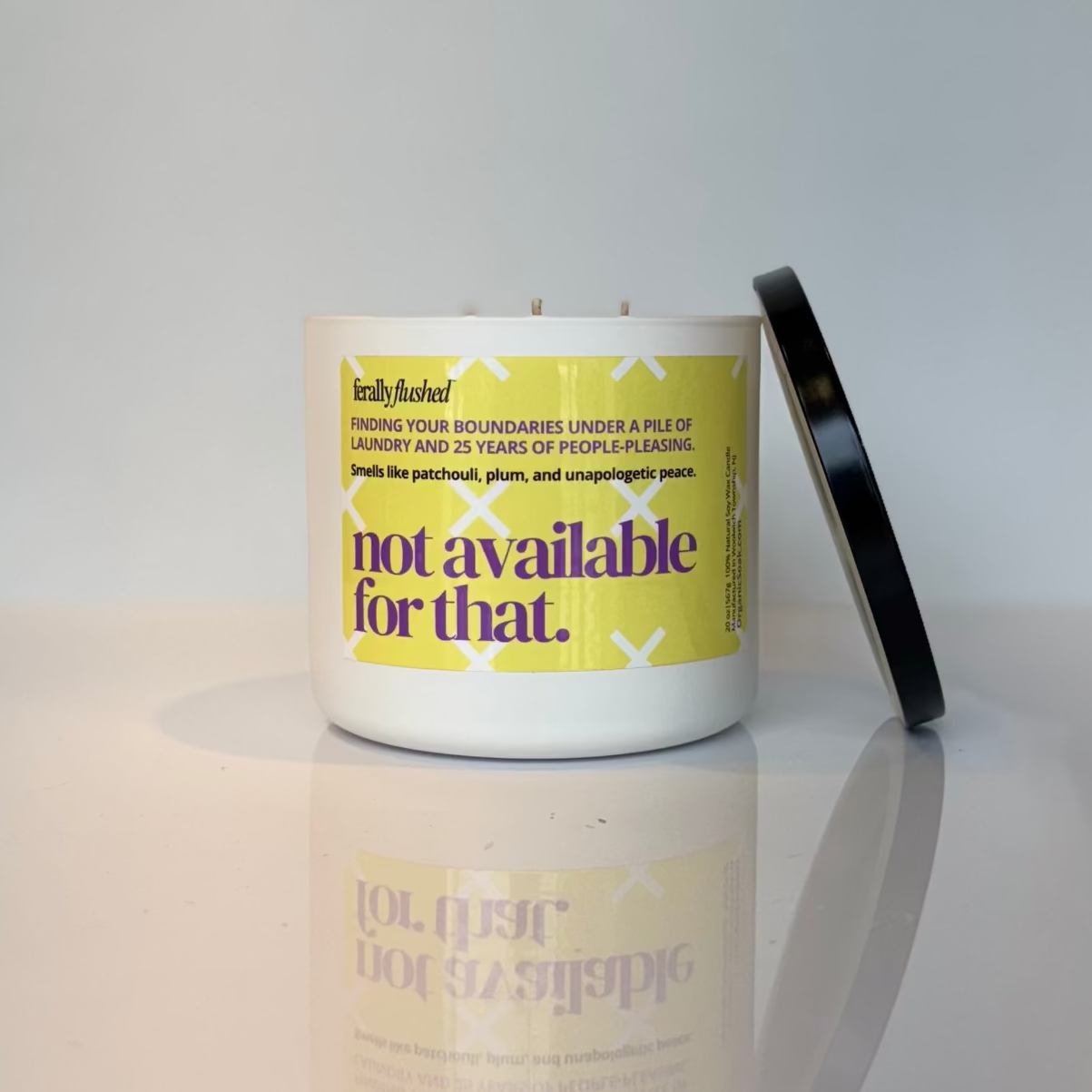 Candle with a yellow label on a white surface