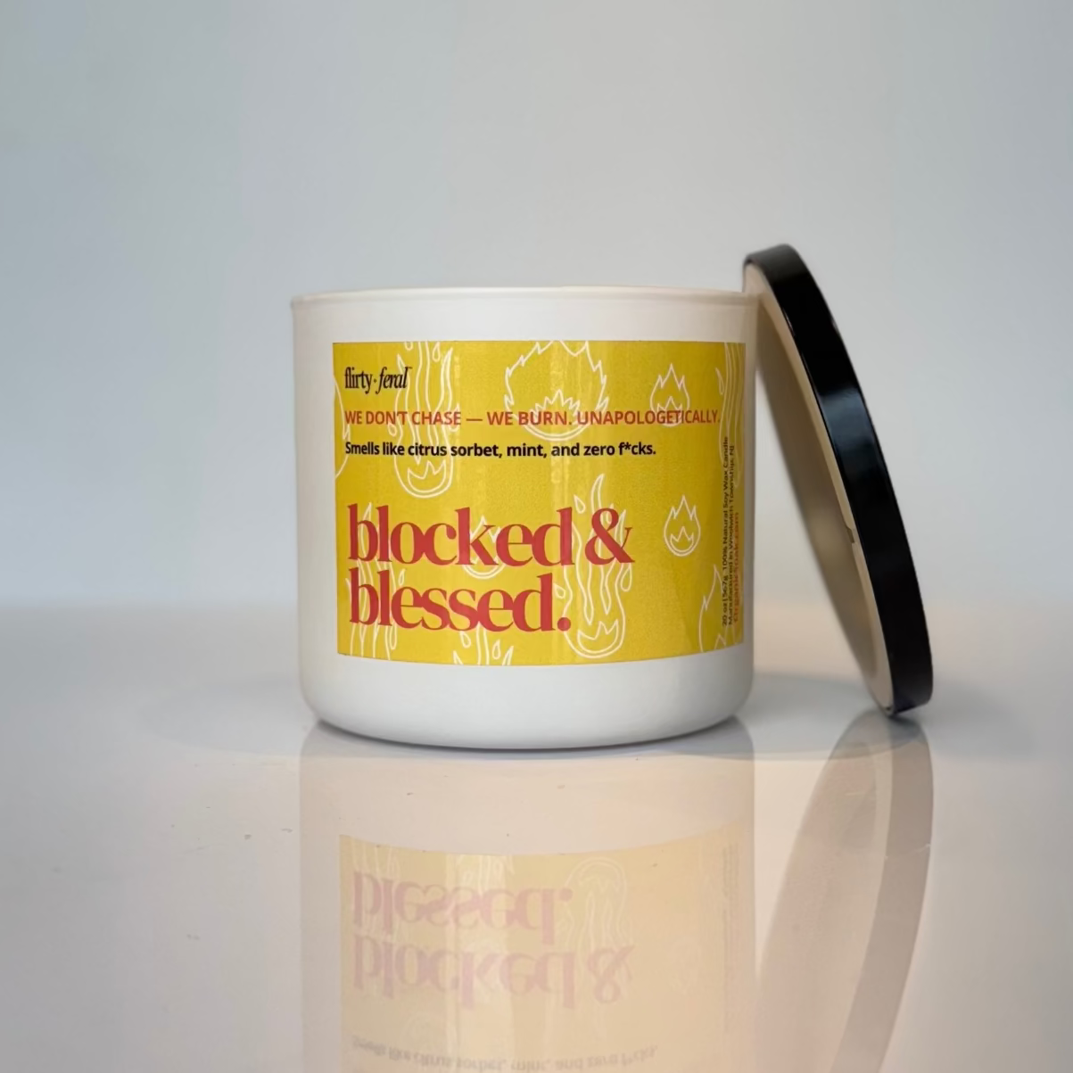 Candle with a yellow label on a reflective surface