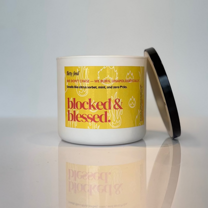 Candle with a yellow label on a reflective surface