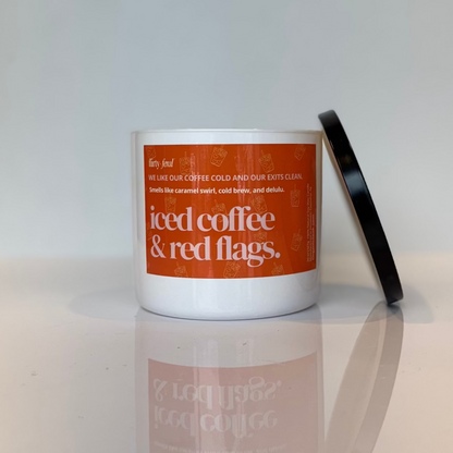 Candle with an orange label on a reflective surface