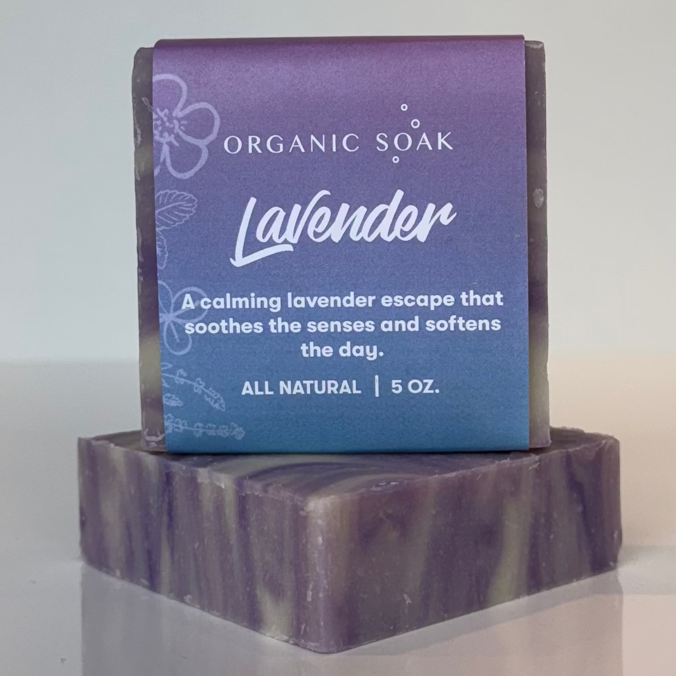 Lavender soap bar on a white surface with a blurred background