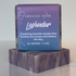 Lavender soap bar on a white surface with a blurred background