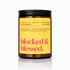 Candle jar with a yellow label on a white background