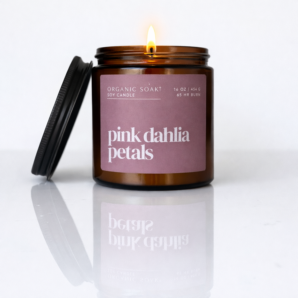 Candle in a brown jar with a pink label reading &