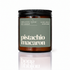 An amber glass jar candle with a black screw-top lid and a muted sage green label reading &