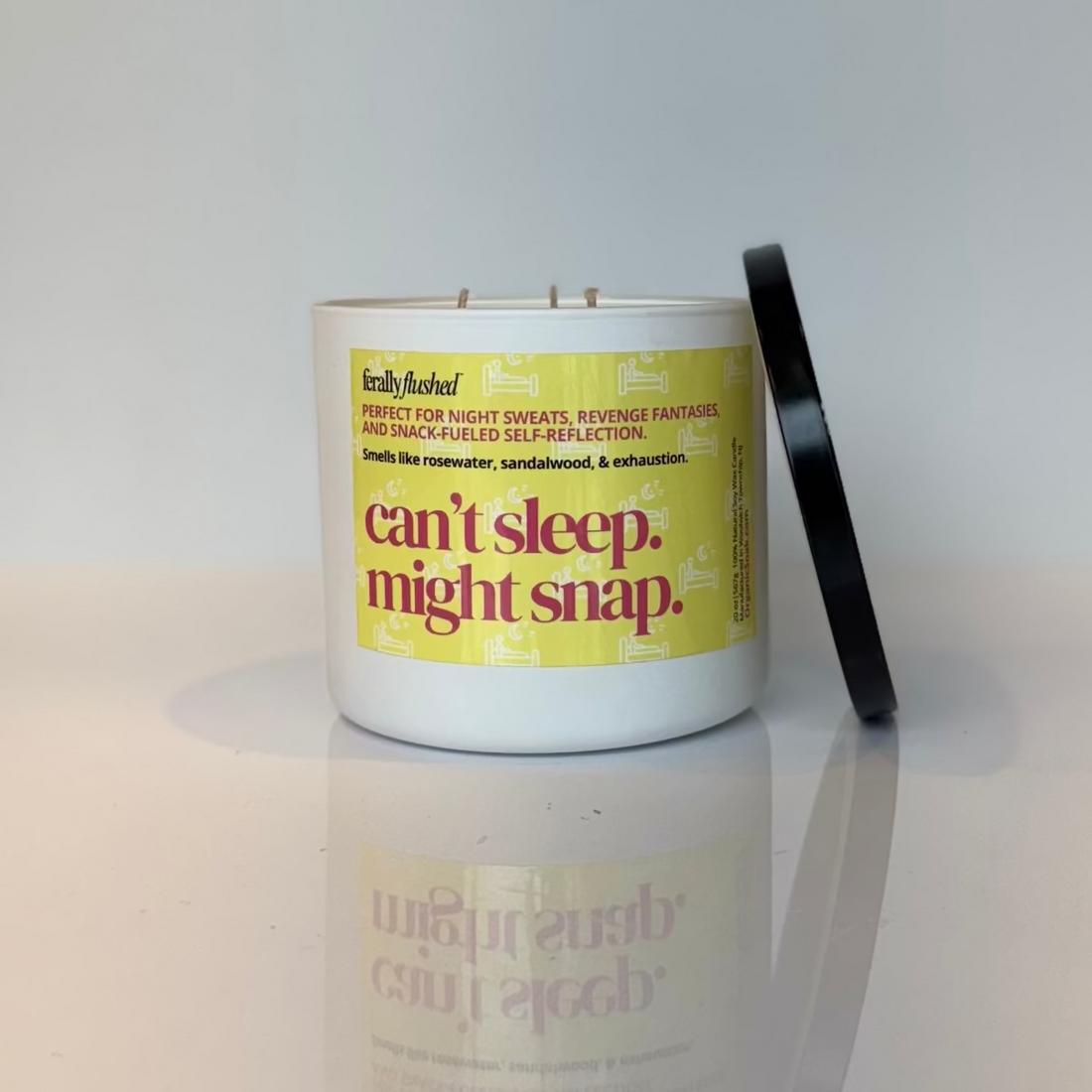 Candle with a yellow label on a white surface