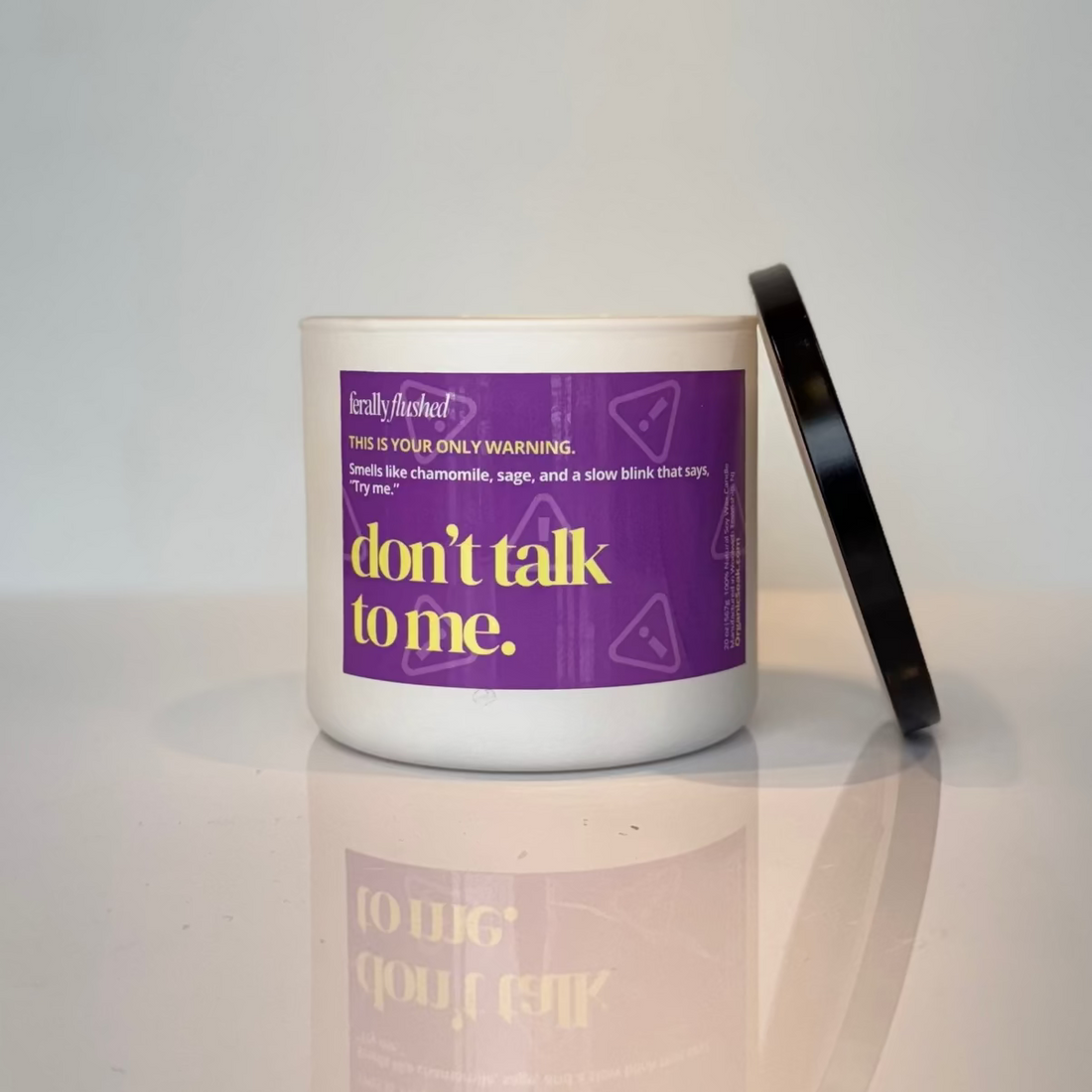 Candle with a purple label on a white surface